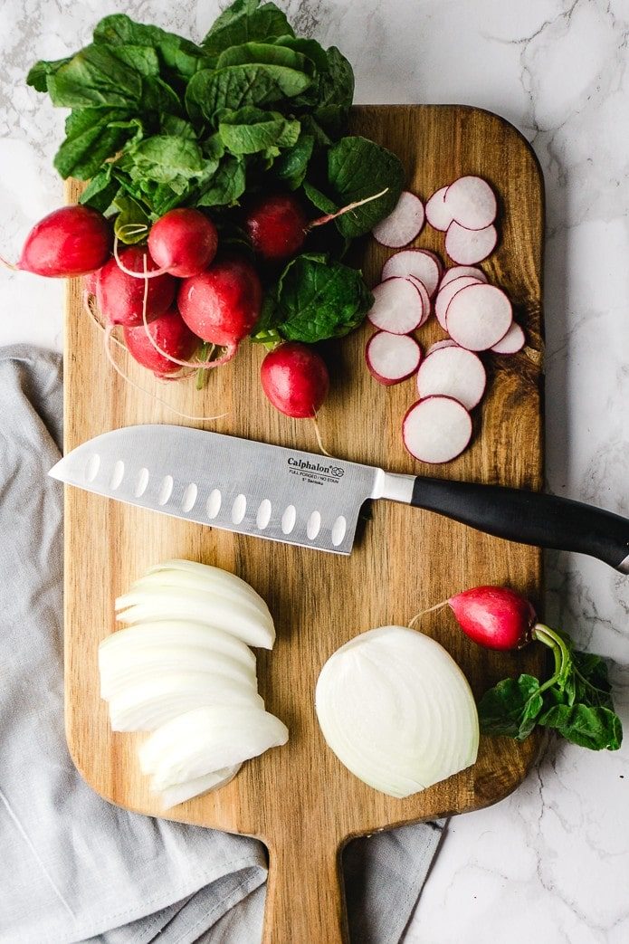 radishes and onions on a cutting board