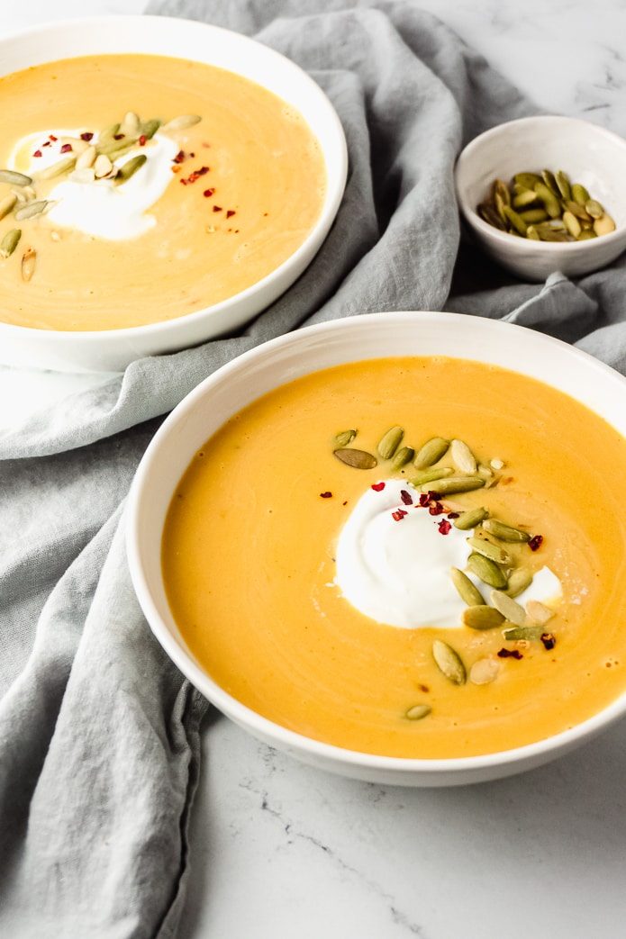 two bowls of keto pumpkin soup with sour cream