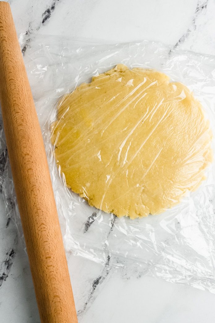 roll out keto pie crust between sheets of plastic or parchment