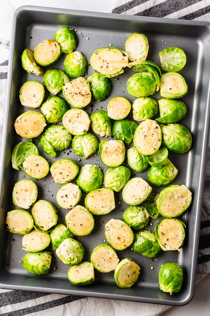raw brussel sprouts on a rimmed baking tray