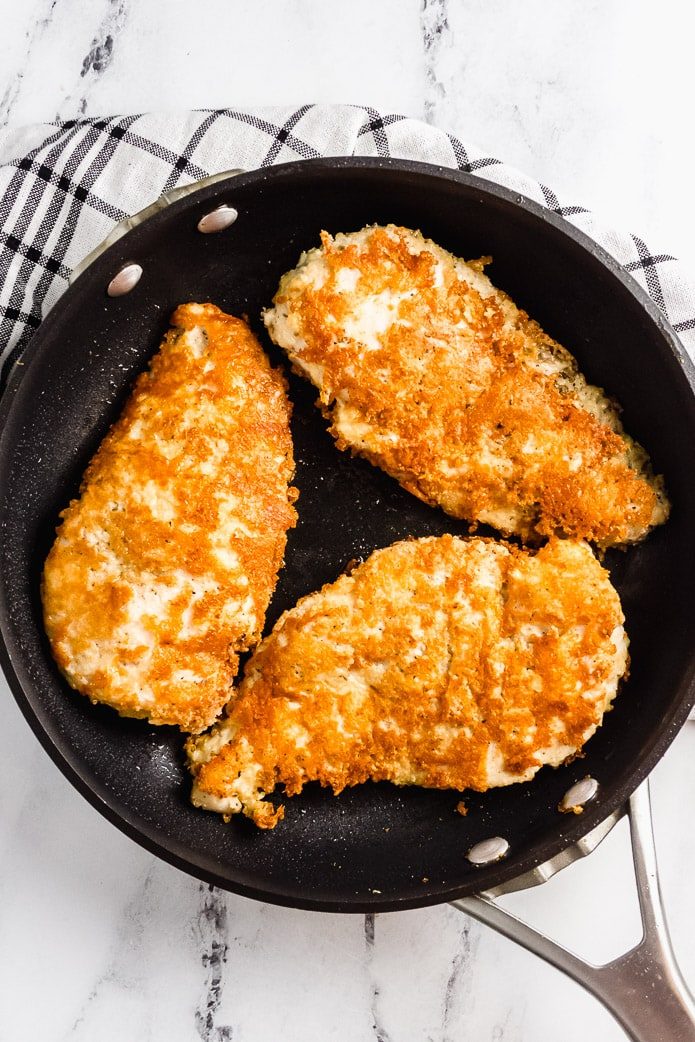 keto parmesan chicken cooked in a skillet on the stovetop